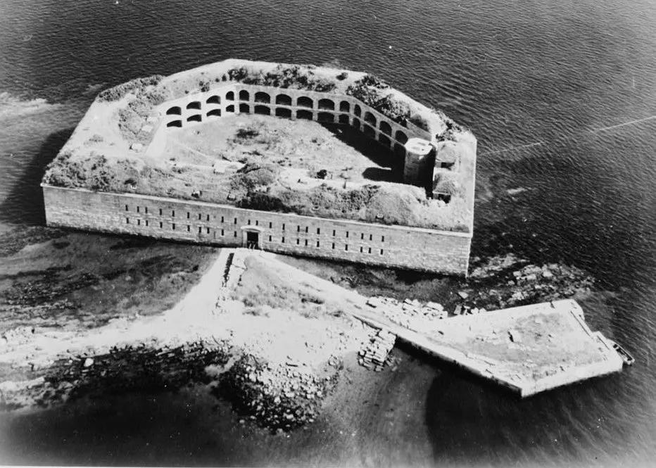 Fort Gorges from the air, in a Historic American Buildings Survey photograph. The archival image shows what the fort still is: unrestored granite casemates on an island in Casco Bay with no ferry service, reached only by private boat or paddle.